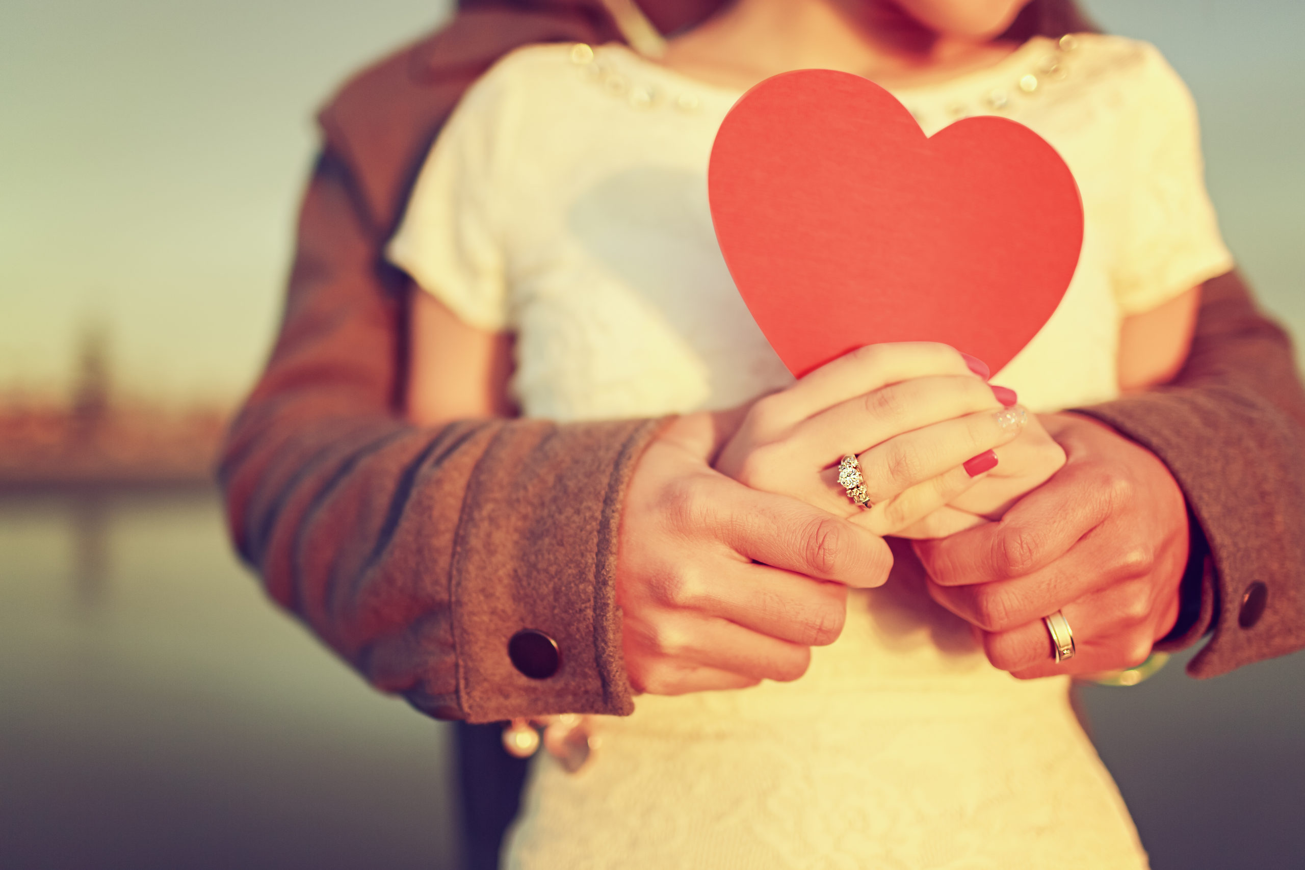 married couple holding a paper heart