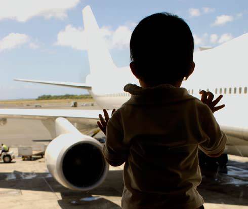child looking at a plane